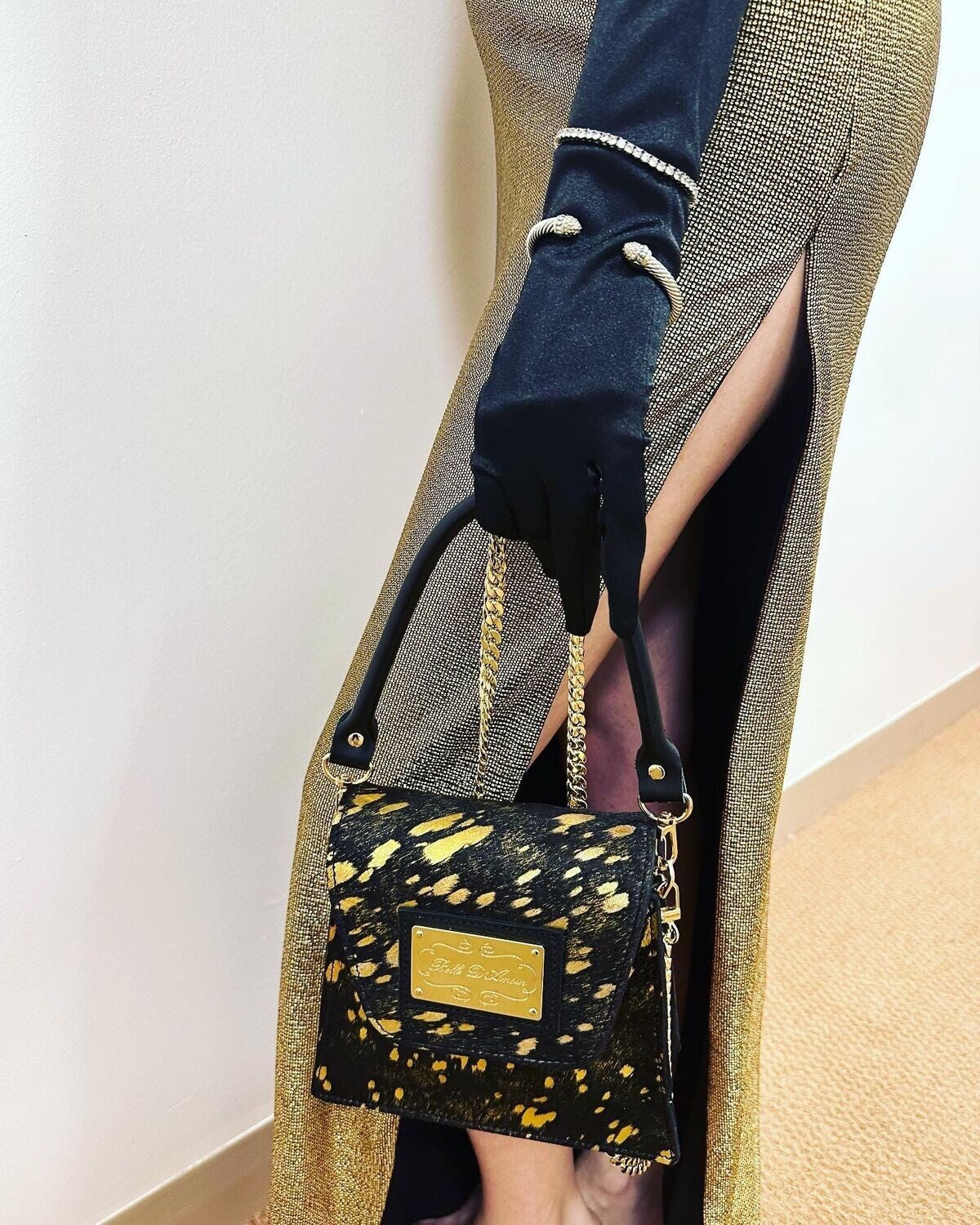 Designer handbag featuring magnetic closure and branded duster bag