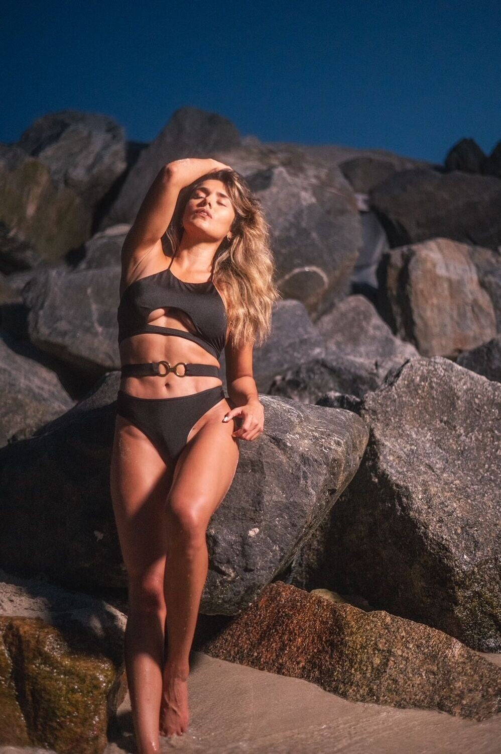 Model wearing black luxury three-piece swimsuit by Belle D’Amour