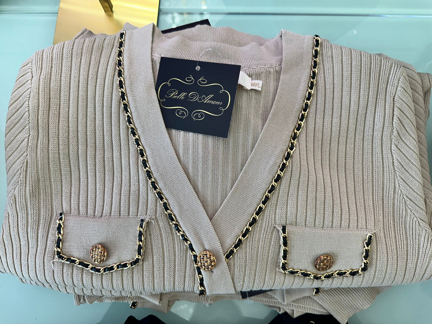 Ribbed cardigan adorned with gold chains and gold buttons