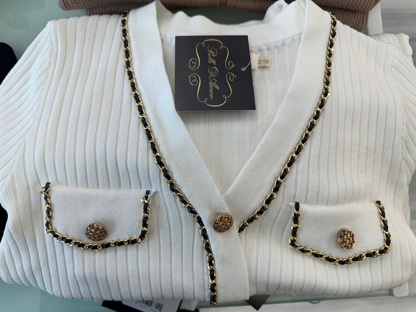 Ribbed cardigan adorned with gold chains and gold buttons