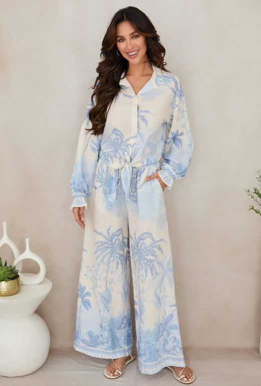 Woman wearing a blue and white floral dress against a beige background