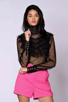 The Juliette Blouse black lace with sheer polka dot pattern, tiered ruffles, high turtleneck, long sleeves, and gold button closures
