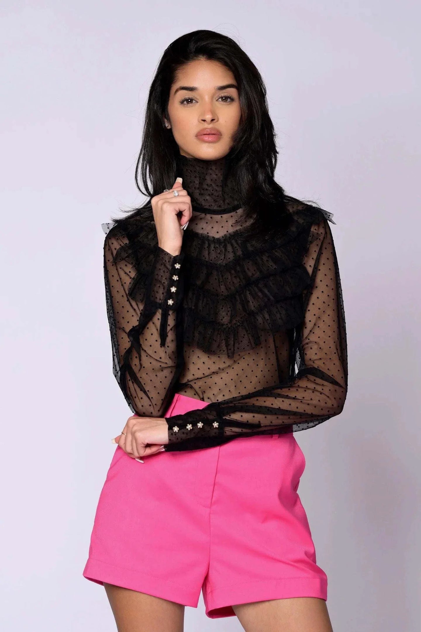 The Juliette Blouse black lace with sheer polka dot pattern, tiered ruffles, high turtleneck, long sleeves, and gold button closures