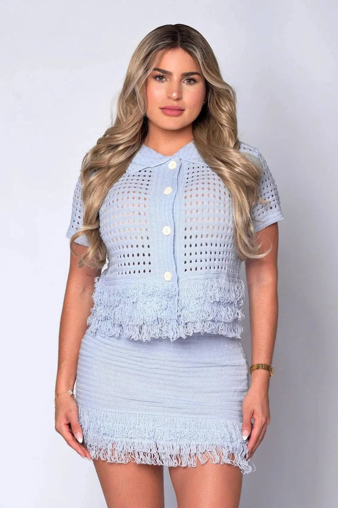 The Monica 2-Piece Fringed Crochet Skirt Set with collared button-up top and mini skirt featuring openwork and fringe detailing