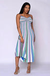 Model wearing the Amara Metallic Knit Dress in multi-stripe jewel tones with spaghetti straps and a fluid midi silhouette
